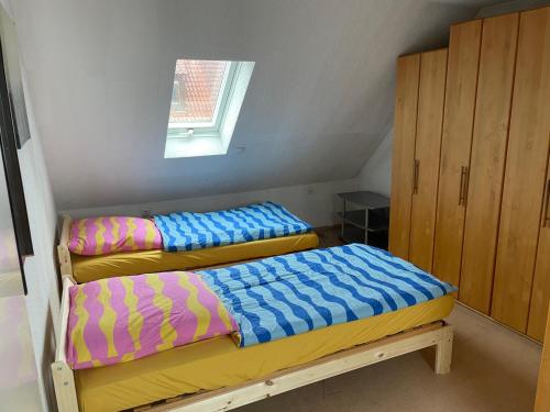 two beds in a small room with a window at Haus Dambacher - Arbeiter-Monteurzimmer in Nürtingen