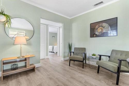 a living room with a table and chairs and a mirror at Stylish Bungalow Steps to Beach! in St Pete Beach