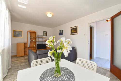 um vaso de flores numa mesa numa sala de estar em Apartments Vlasta 1410 em Premantura