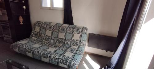kanapę siedzącą w pokoju z oknem w obiekcie Studio face verdure w mieście Montreuil