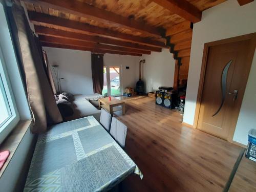 sala de estar con suelo de madera y mesa en Mountain Cozy Home, en Sub Cetate