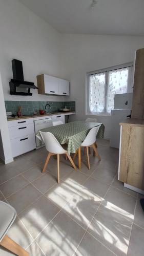 une cuisine avec une table et des chaises dans une pièce dans l'établissement La vouivre, à Saint-Remèze