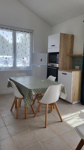 une cuisine avec une table et des chaises dans une pièce dans l'établissement La vouivre, à Saint-Remèze