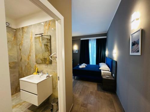 a bathroom with a sink and a bed in a room at Sunset Guest House in Reggio Calabria