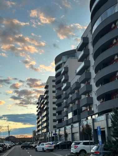 a building with cars parked in a parking lot at Zen Apartment Oradea - FREE Parking in Oradea