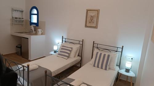 a small room with two beds and a kitchen at BlackBeach village in Perissa