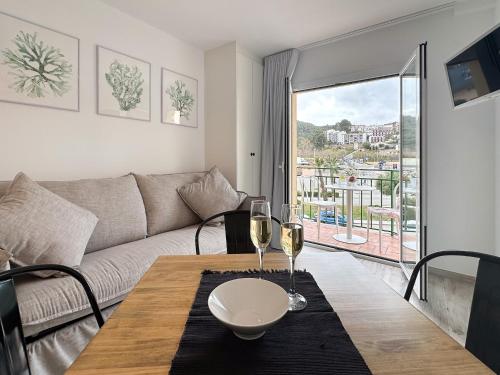 a living room with a table with two glasses of wine at Suite apartment mar menuda in Tossa de Mar