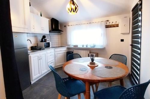 une cuisine avec une table et des chaises dans une cuisine dans l'établissement Appartement Cosy Ploumanac'h classé 2 étoiles, à Perros-Guirec