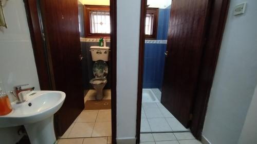 a bathroom with a toilet and a sink and a toilet istg at The Forest House - Kawuku-Bunga in Kampala