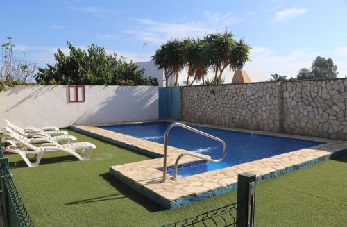 コニル・デ・ラ・フロンテーラにあるApartamento en Conil con piscinaの小さなスイミングプール(椅子、フェンス付)