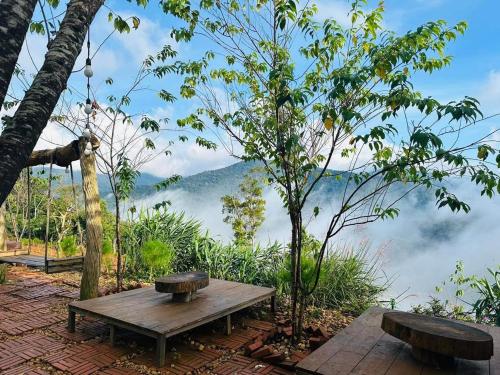 a wooden picnic table with a view of the mountains at TopView Măng Đen in Kon Von Kla