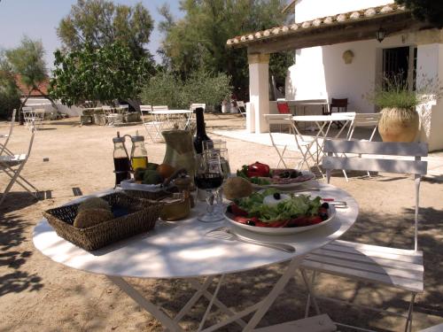 a table with a plate of food and a bottle of wine at Cacharel in Saintes-Maries-de-la-Mer