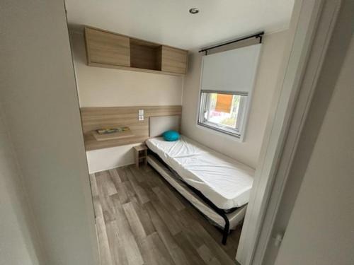 - un petit lit dans une petite chambre avec fenêtre dans l'établissement Mobile- Home AMIRA, à Valras-Plage