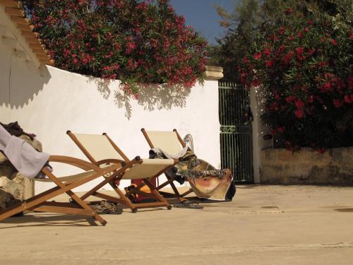 a couple of chairs sitting next to a building at Cacharel in Saintes-Maries-de-la-Mer