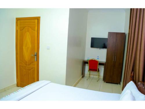 a bedroom with a bed and a desk and a television at Macchiato Suites in Kigali