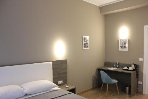 a bedroom with a bed and a desk with a chair at Sunset Guest House in Reggio Calabria