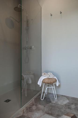 a bathroom with a shower and a stool with a towel on it at Masseria San Giovanni - Epoca Collection in Fasano