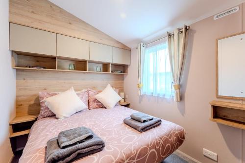 a bedroom with a bed with two towels on it at 30 Bayside Cove Pevensey Bay Holiday Park in Pevensey