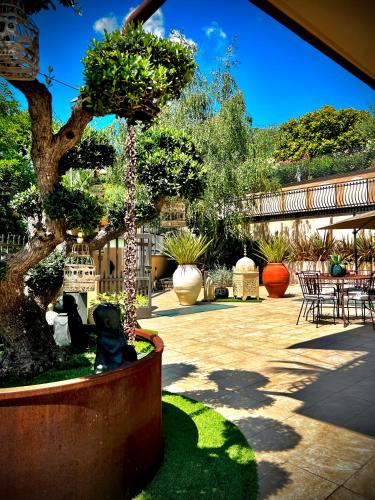 a garden with a bonsai tree and tables and chairs at WELCOME TRAVELLER FRIDA'S ROOMs in Caprino Veronese