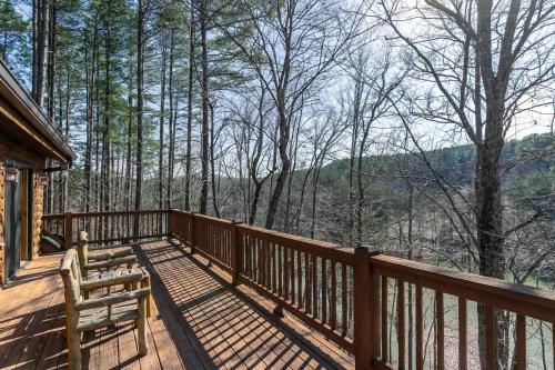 a deck with a bench and a view of the woods at Our Neck of the Woods at Hidden Lake in Nebo