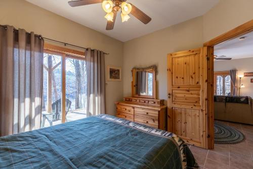 a bedroom with a bed and a dresser and a window at Our Neck of the Woods at Hidden Lake in Nebo