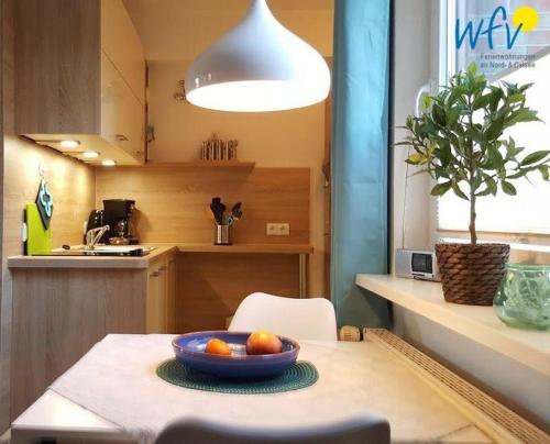 a kitchen with a table with a bowl of fruit on it at Haus Colonia - Wohnung 3 in Wangerooge