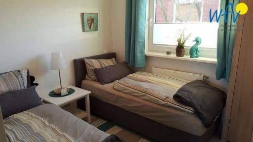 a small bedroom with a bed and a window at Haus Colonia - Wohnung 3 in Wangerooge