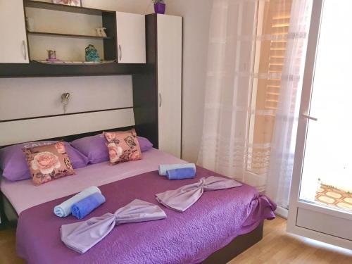 a bedroom with a purple bed with towels on it at Villa Marga in Jelsa