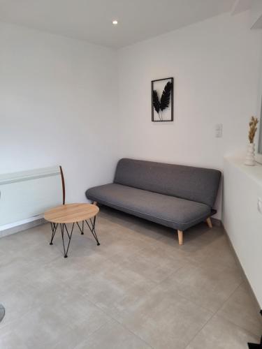 un sofá y una mesa en una habitación en L'Epicerie, en Baccarat