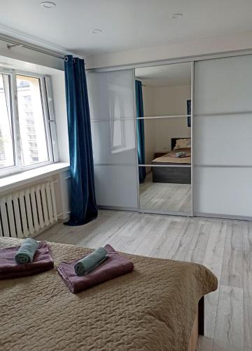 a bedroom with a large mirror and a bed at Vytekstos Apartamentai in Druskininkai
