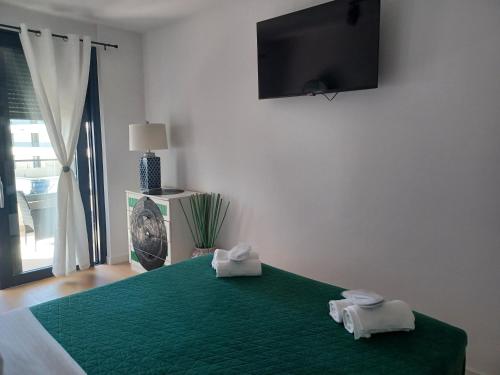 um quarto com uma cama verde e 2 toalhas em Apartment Gabi em Zadar
