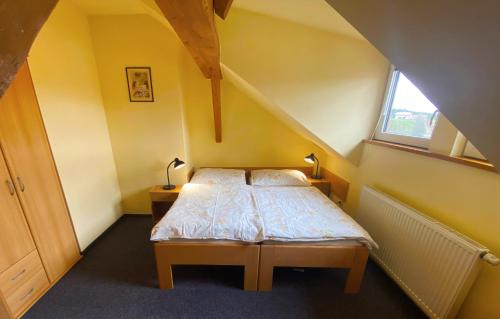 a small bedroom with a bed in a attic at Penzion Pod Ždánovem in Nezdice