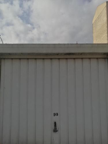 un bâtiment blanc avec son numéro dans l'établissement Centre Ville Parking Privé, à Les Pavillons-sous-Bois