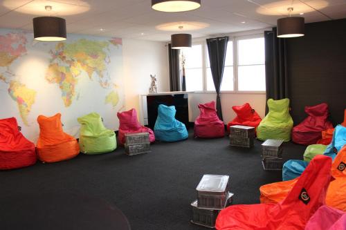 a room with colorful chairs and a world map on the wall at Clos De La Vaupalière - Rouen in La Vaupalière