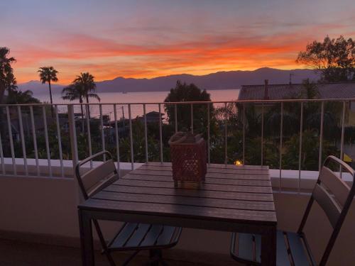 a wooden table on a balcony with a view of the ocean at Thalassa Suite & Spa in Reggio Calabria