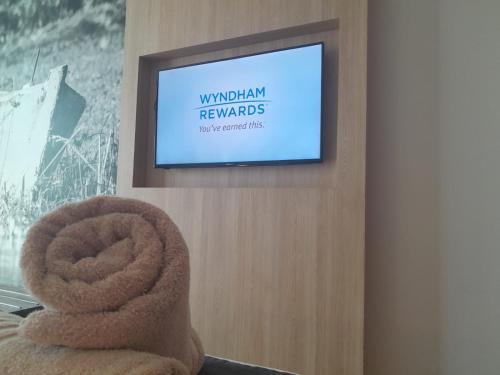 a television on a wall in a room at Dazzler by Wyndham Rosario in Rosario
