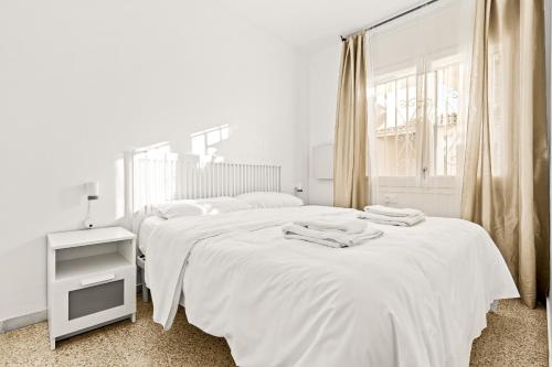 um quarto branco com 2 camas e uma janela em Apartamento Welcs EMP-127-con vistas al canal em Empuriabrava