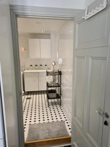 a white bathroom with a black and white tiled floor at Porvoo City Apartments in Porvoo