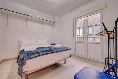 um quarto branco com uma cama e uma janela em La Ciudadela by Clabao em Pamplona