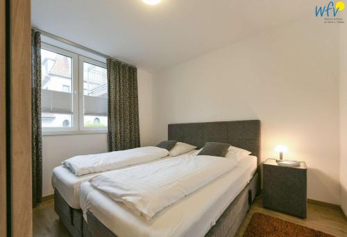 a bedroom with two beds and a window at Haus Oldenburg Ferienwohnung 5 in Wangerooge