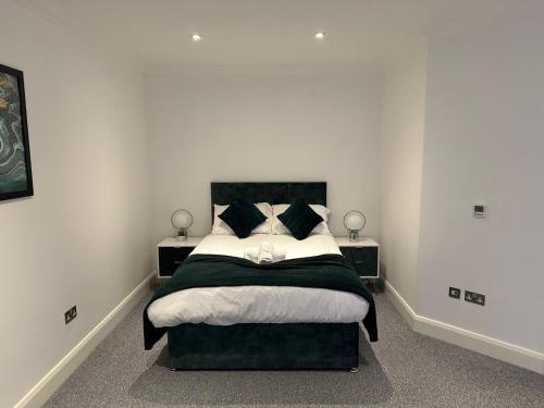a bedroom with a large bed with black and white pillows at Cromwell Court Apartments in Huntingdon