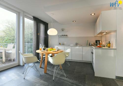 Una cocina con una mesa y sillas en una habitación. en Haus Oldenburg Ferienwohnung 7, en Wangerooge