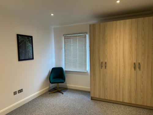 a room with a door and a chair and a window at Cromwell Court Apartments in Huntingdon