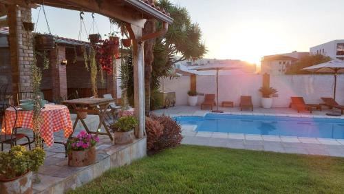 a backyard with a pool and a table and chairs at Villa dos Corcéis in Esposende