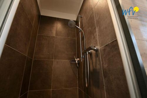 a shower with a glass door in a bathroom at Alte Feuerwache Ferienwohnung 1 in Wangerooge