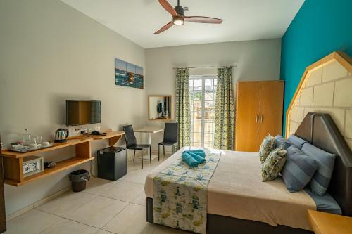 a bedroom with a bed and a table and chairs at Il-Logga Boutique Hotel in Xagħra