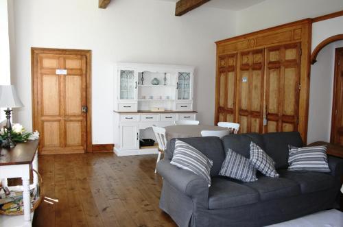 een woonkamer met een bank en een tafel bij Le Farat Bed & Breakfast in Auvillar