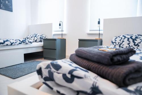 een kamer met 2 bedden en een stapel dekens bij Apartment Hafenarbeiter in Bremerhaven