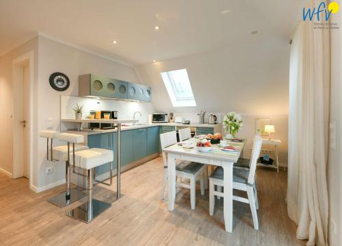 a kitchen and dining room with a table and chairs at Bootshaus in den Duenen - 4 "Ferienwohnung Sonnendeck" in Wangerooge