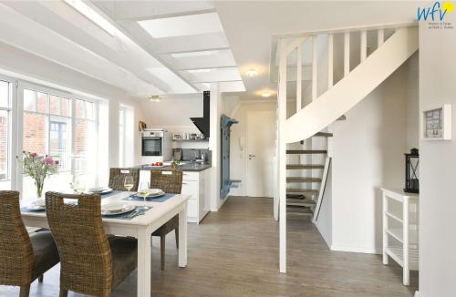 a kitchen and dining room with a table and a staircase at Bootshaus in den Dünen Ferienwohnung 4 in Wangerooge